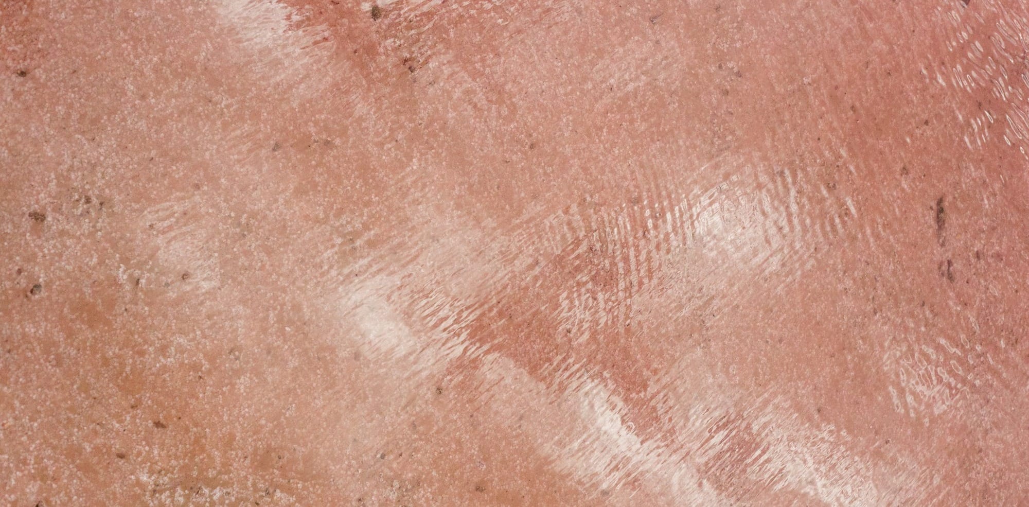 Textured pink surface with a reflective shine.